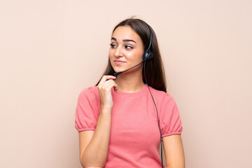 Young woman over isolated background working with headset