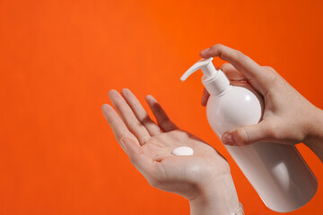 Woman's hands applying lotion isolated