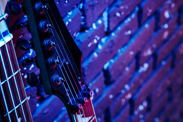 Guitar headstock with tuners on dark background