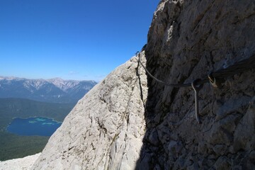 Stahlseil am Fels über einem See in Bayern