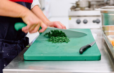 Unrecognized woman cutting parsley