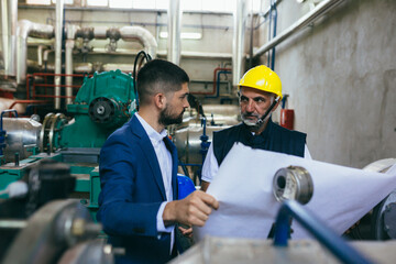 industry worker and his manager working indoor in heating plant