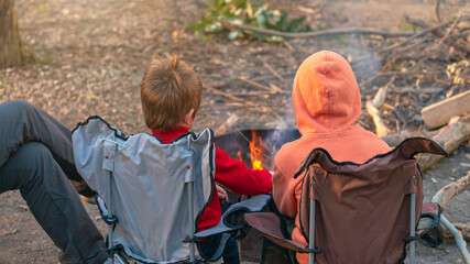 Kids burning campfire in the forest camping grounds during winter school holidays, Kuitpo, South Australia