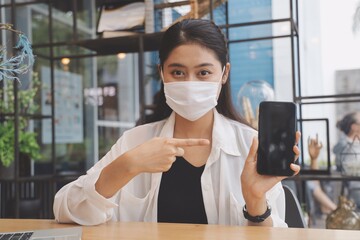 Asian woman using smart phone in coffee shop.