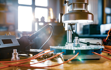 Modern microscope, connectors component and large green microcircuit in workshop laboratory