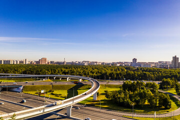 Fototapeta na wymiar a panoramic view of the road with a complex system of interchanges with the city in the background filmed from a drone