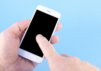 Image of male hands. One hand holds a white smartphone, while the other hand touches the screen with a finger.
