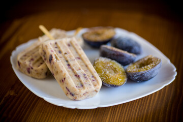 plum sweet homemade ice cream on a stick with slices of plum inside, in a plate