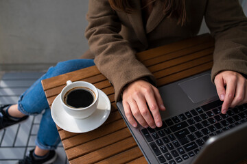 Fototapeta na wymiar Woman working in street cafe with laptop