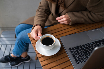 Woman working in street cafe with laptop