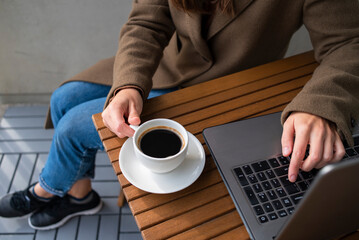 Woman working in street cafe with laptop