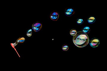 Flying soap bubbles isolated on black background.