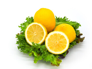 Lemon and half sliced lemon on salad leaves