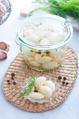 pickled garlic with spices in a glass bowl, selective focus