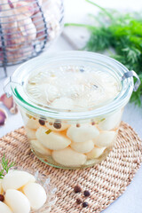 pickled garlic with spices in a glass bowl, selective focus