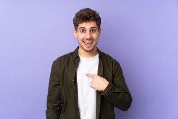 Caucasian man isolated on purple background with surprise facial expression