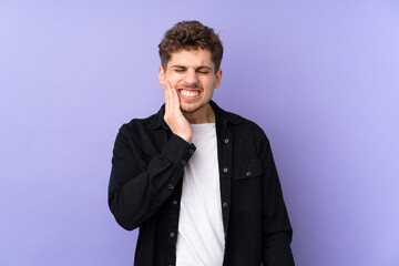 Caucasian man isolated on purple background with toothache