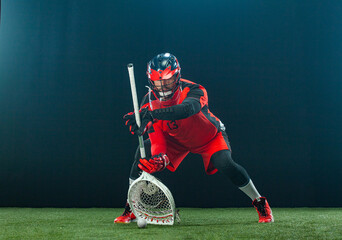 Lacrosse Player, athlete sportsman in red helmet on dark background. Sport and motivation wallpaper.