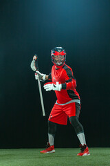 Lacrosse Player, athlete sportsman in red helmet on dark background. Sport and motivation wallpaper.