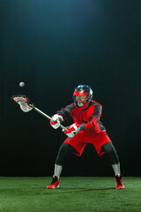 Fototapeta na wymiar Lacrosse Player, athlete sportsman in red helmet on dark background. Sport and motivation wallpaper.