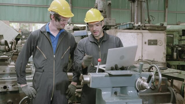 Two engineer man training work with laptop computer together in factory industrial, planning and project, technician, foreman and employee talking and discuss about technician and project.