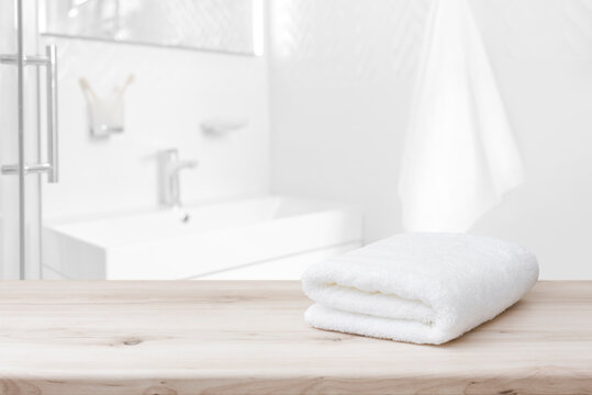 White towel with space on wood and blurred bathroom interior