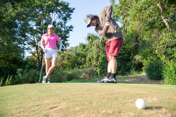 Happy and cheerful of the woman golf player in winning putt a ball completed into the hole on the...