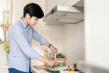 Asain man cooking in the home kitchen.