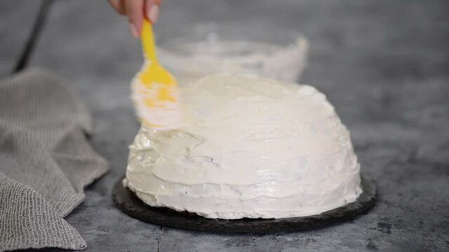 Close up of woman preparing cake with vanilla cream at home. Making Pancho Cake with Sour Cream.