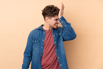 Caucasian man isolated on beige background having doubts with confuse face expression