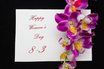 Happy Womans Day March 8th written on white card with red roses