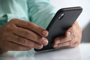 Man working in workplace on mobile in hands