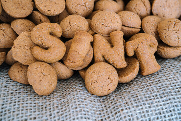 Dutch holiday Sinterklaas background with kruidnoten, traditional Sinterklaas sweets.. Pepernoten on sacking for sweets and gift boxes. Concept for children party Saint Nicolas day five december.