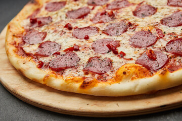 Delicious Italian Pizza pepperoni with mozzarella cheese and salami on dark background