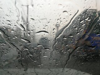 Road view through car window with rain drops, Driving in rain.
