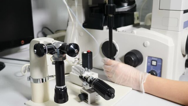 Reproductive medicine in modern medical laboratory. Fertility specialist performing icsi ivf procedure moving joystick to adjust micromanipulator needles. Artificial insemination. 4 k video