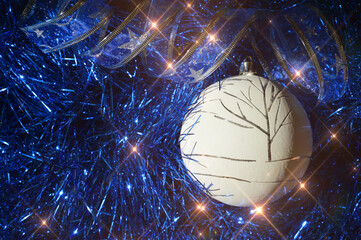 blue shiny tinsel and a white Christmas ball. decoration for Christmas and new year.