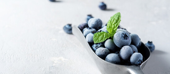 A scoop of frozen blueberries on a concrete surface.