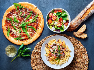 pizza with salat and pasta ready to eat on a stone undergound.