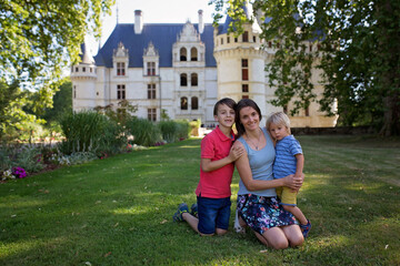 Mother and children in castle garden, smiling at camera, castle on Loire Valley