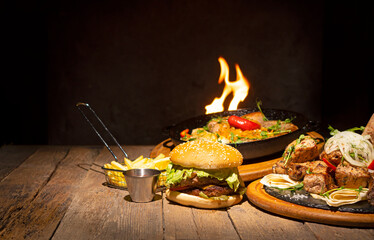 Grilled food background with hamburger, sausages, meat and french fries.