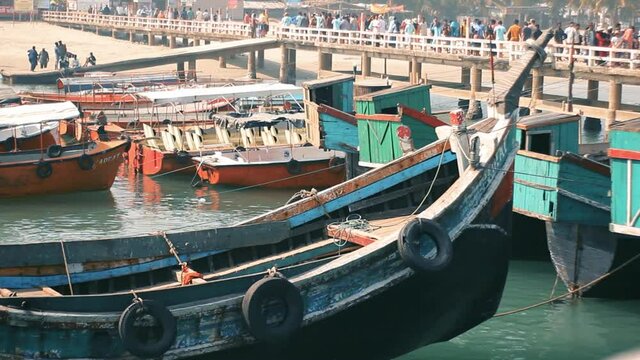 Time lapse of Wooden boats floting on blue sea water and heap of tourist people walking on bridge which locally known as boat's zeti .