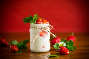 sweet homemade yogurt with ripe fresh strawberries in a jar