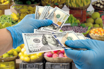 Hands in blue gloves pass dollars in the supermarket. shopping concept