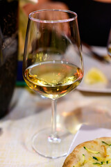 Glass of cold dry white wine served outdoor in cafe at night in Italy
