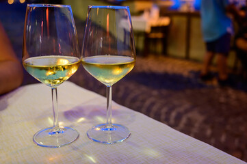 Two glasses of cold dry white wine served outdoor in cafe at night in Italy