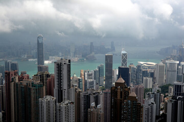 High modern buildings in fog and thick rain clouds of Hong Kong harbor from view point