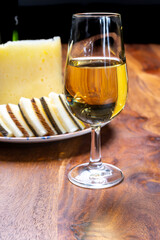 Naklejka premium Spanish fino sherry wine from Andalusia and pieces of different sheep hard manchego cheeses made in La Mancha, Spain. Wine and cheese pairing