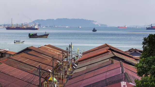 High angle view of cityscape and boat traffic in the harbor with amazing cloud moving as background on a mountain range in Butterworth, clan jetties Georgetown, the capital of Pulau Penang, Malaysia.