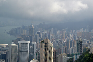High modern buildings in fog and thick rain clouds of Hong Kong harbor from view point